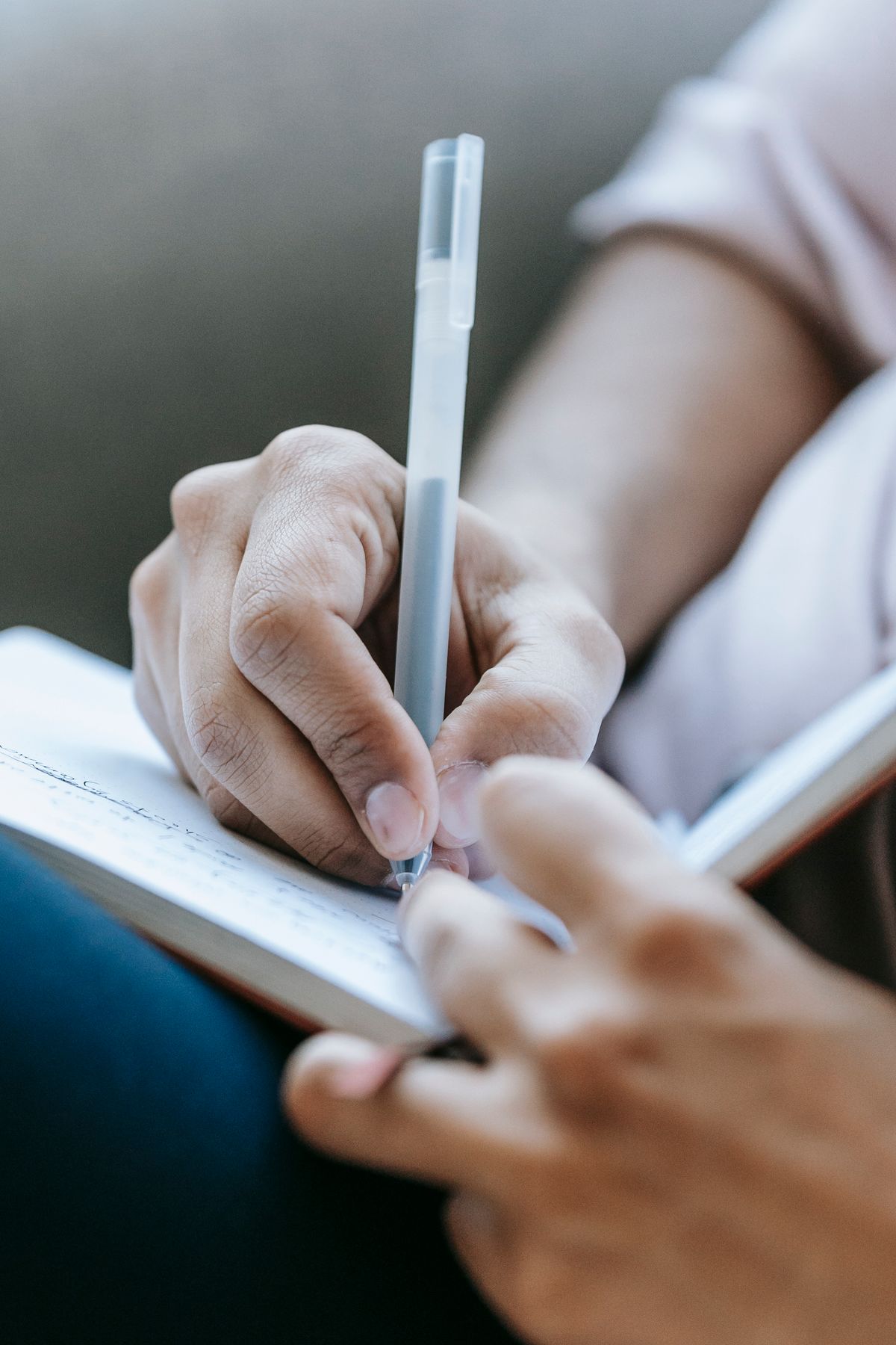 Mains écrivant dans un carnet, symbole d'un accompagnement personnalisé